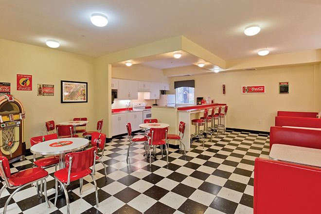 Retro-style diner with red chairs and a classic checkerboard floor.