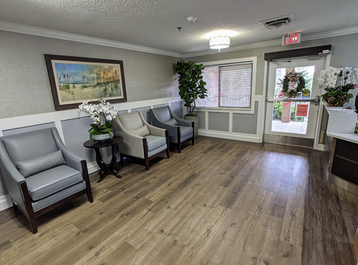 A welcoming waiting area featuring comfortable chairs, decorative plants, and artwork.