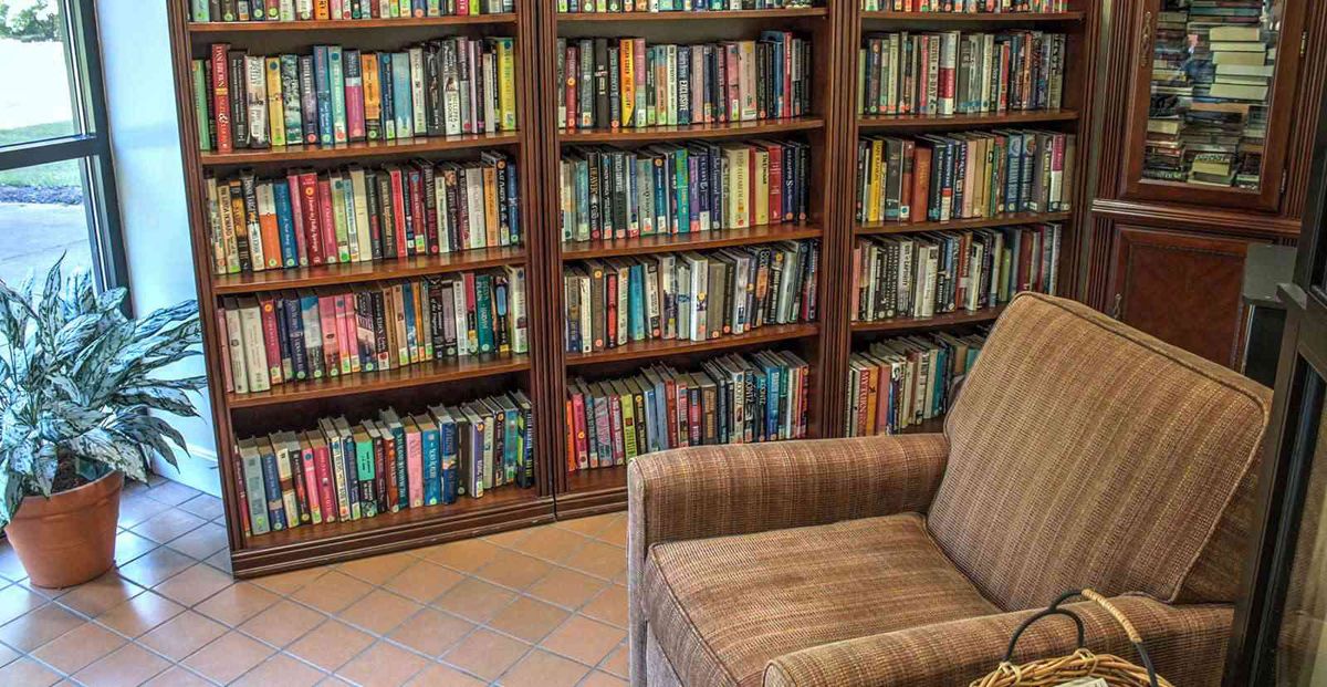 A cozy library corner with bookshelves filled with books and a comfortable chair.