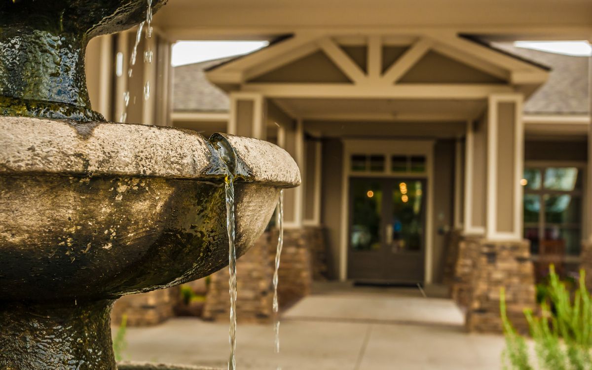 A close-up of a flowing fountain in front of a building entrance.