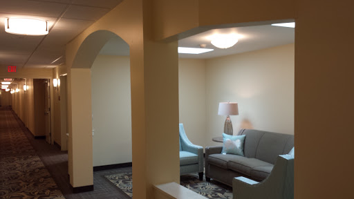 A cozy lounge area featuring a gray sofa and a stylish lamp.