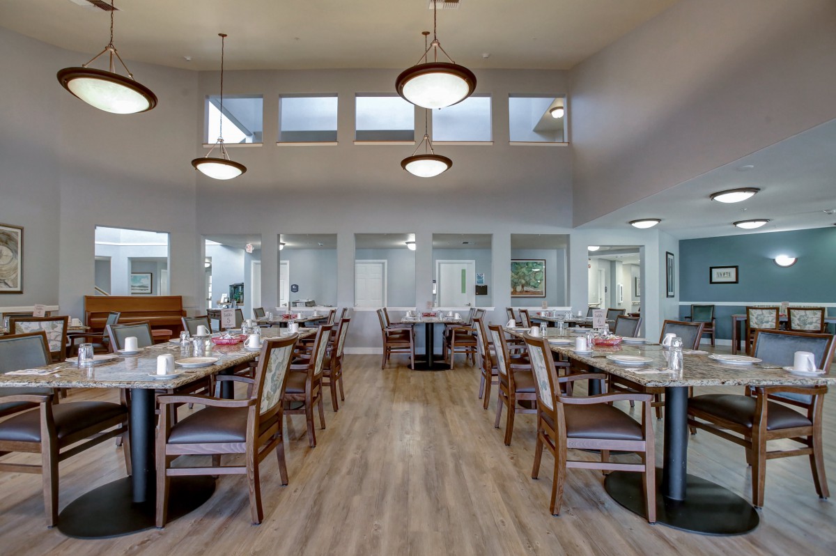 A spacious and modern dining room with neatly arranged tables and elegant lighting.