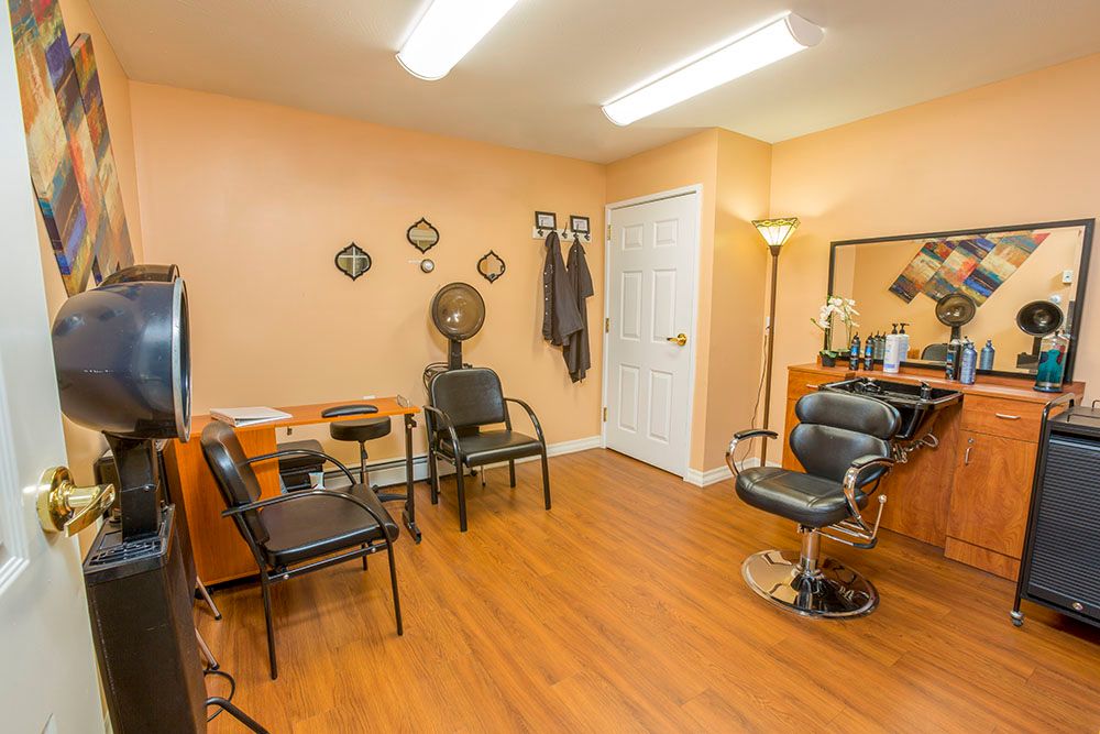 Interior of a salon with chairs, mirrors, and hairdressing equipment.