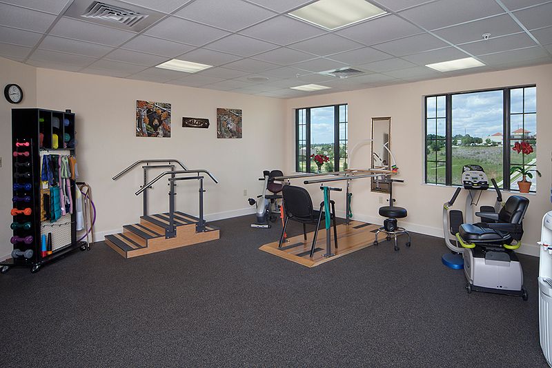 A physical therapy room equipped with parallel bars and stairs for rehabilitation exercises.