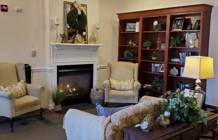 A cozy living room with a fireplace, armchair, and bookshelf, highlighting warm home decor.