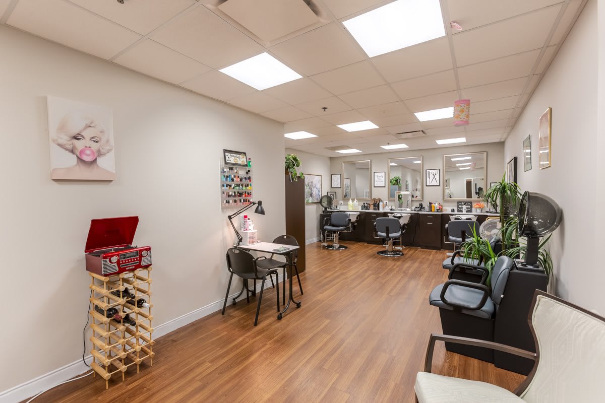 A modern nail salon interior with manicure stations and bright lighting.
