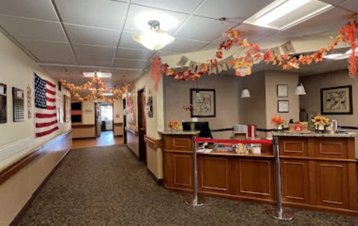 A warmly decorated office reception area with autumn-themed decorations.