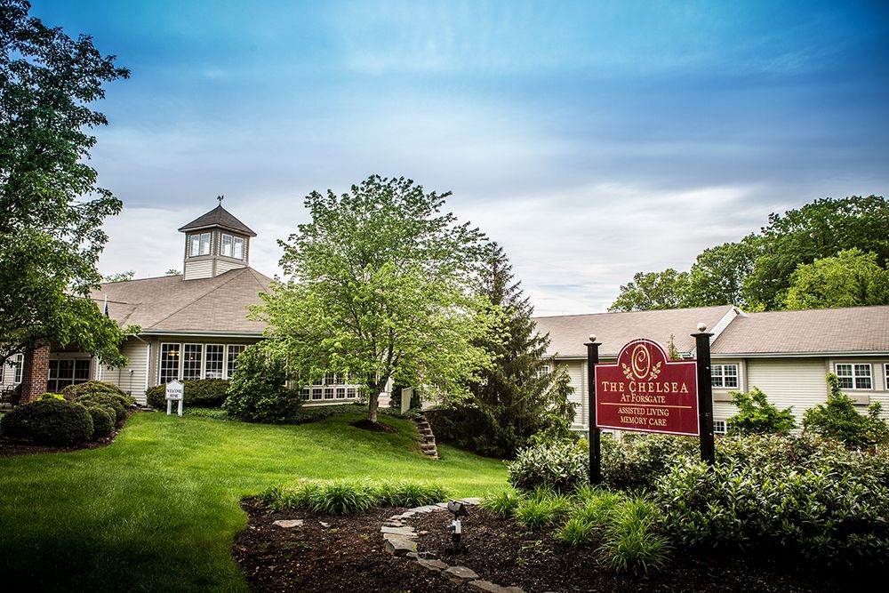 A serene countryside building with a prominent sign and lush greenery.
