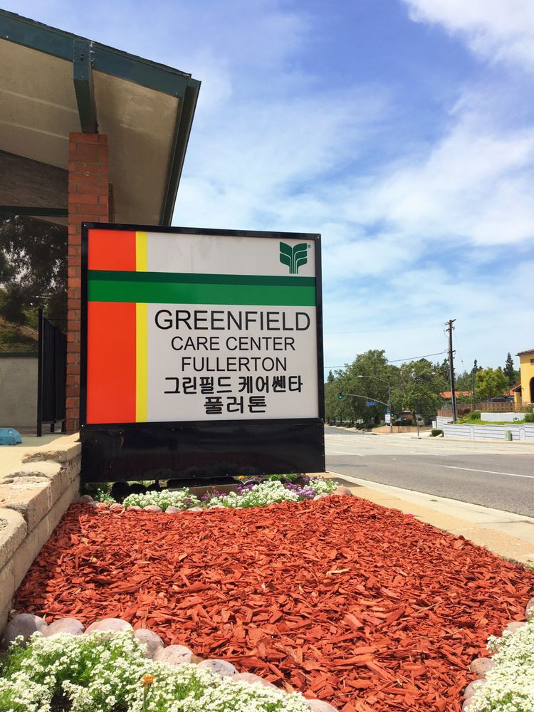 Sign for Greenfield Care Center Fullerton on a sunny day.