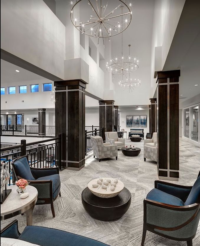 A modern lobby area featuring elegant seating arrangements and striking chandeliers.