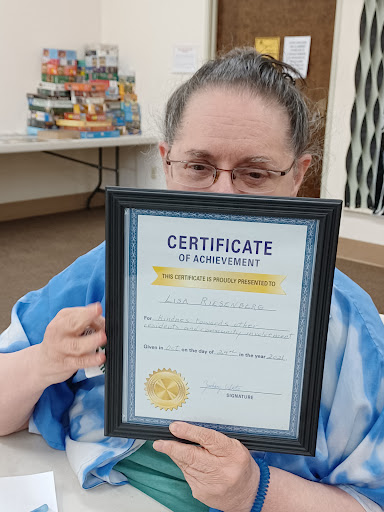 A proud individual holding a certificate of achievement, showcasing their hard work and dedication.