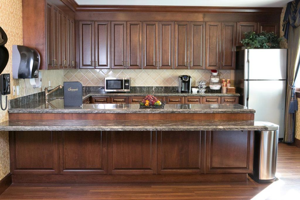 A modern kitchen with wooden cabinets and various appliances on the countertop.