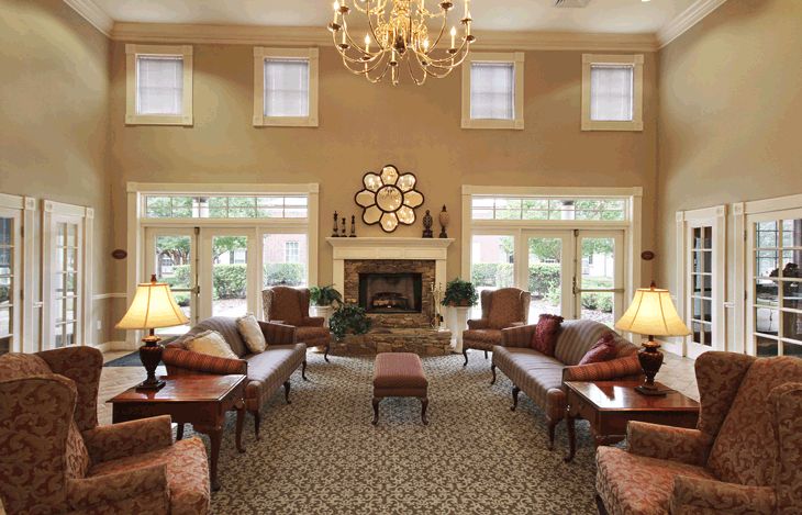 Elegant living room with a central chandelier, cozy fireplace, and comfortable seating.
