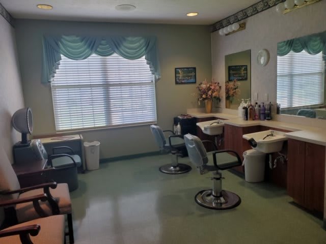 An empty hair salon with styling chairs and mirrors.
