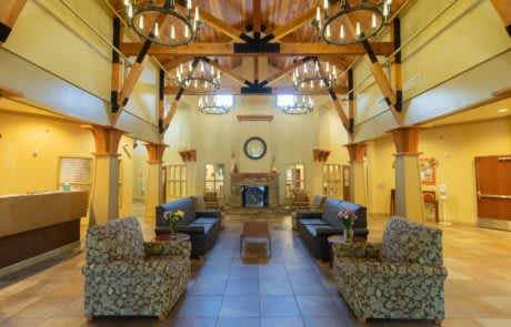 A spacious lobby with elegant chandeliers, a fireplace, and comfortable seating arrangements.