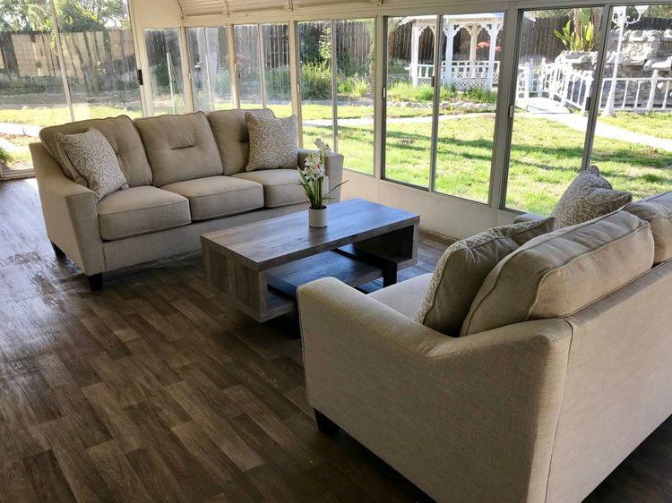 Bright sunroom with comfortable seating and a coffee table overlooking the garden.