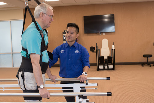 A physical therapist assists a patient during rehabilitation exercises in a modern fitness facility.