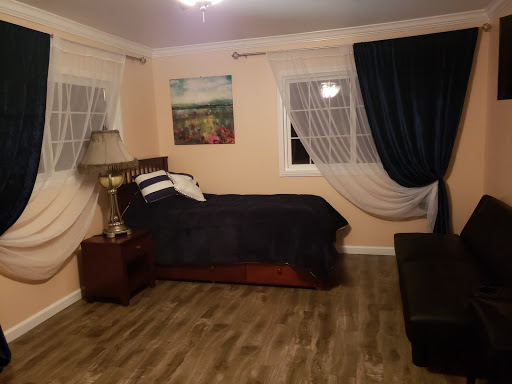 A cozy and well-decorated bedroom featuring a bed, lamp, and elegant curtains.