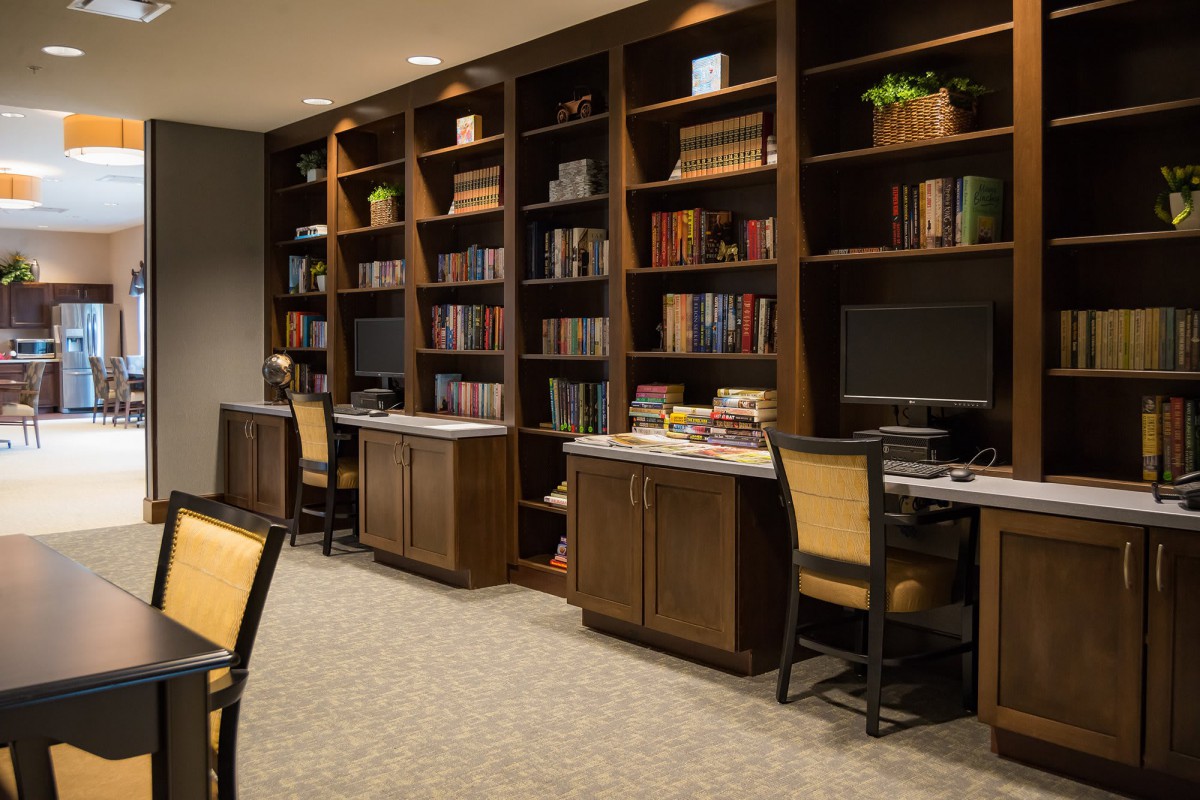 A cozy library space with bookshelves and computer stations.