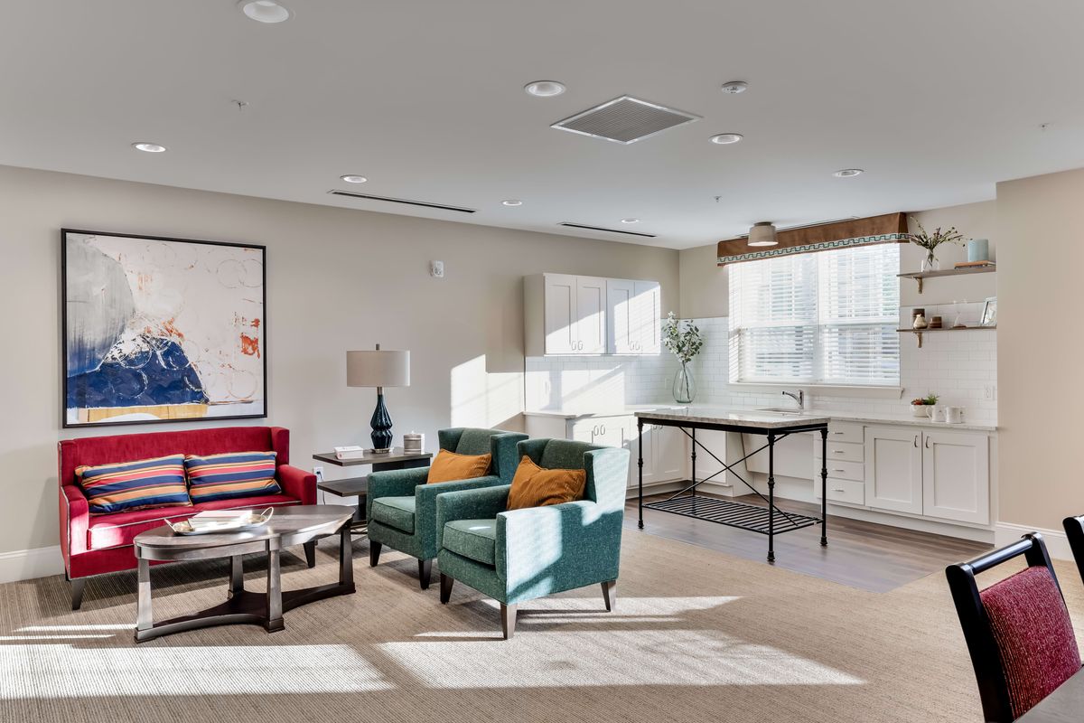 A modern living room with stylish furniture and large windows allowing natural light.