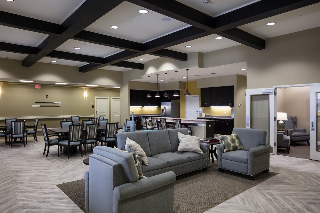 A modern open-plan living area with stylish furniture, including sofas and a dining table, seamlessly integrated with a kitchen.
