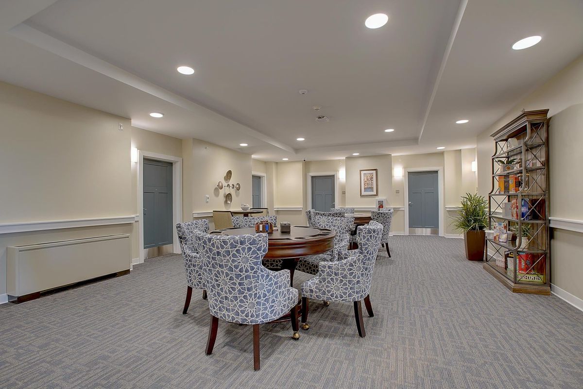 A spacious meeting room with patterned chairs and a round table, well-lit and tastefully decorated.