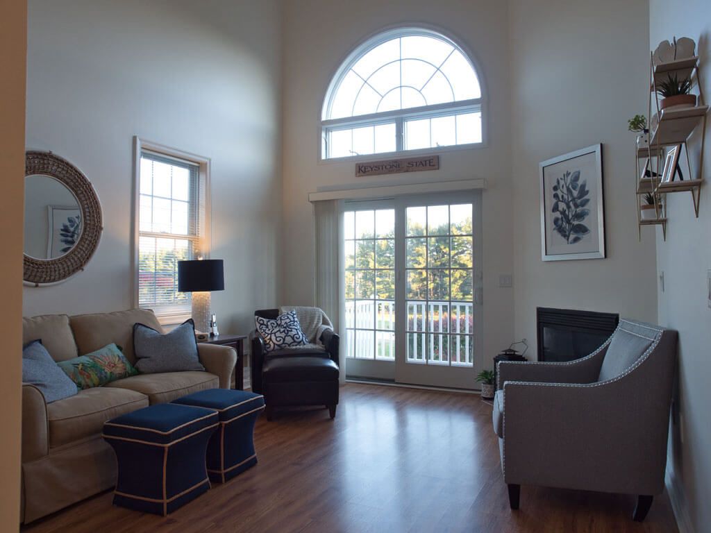 A spacious and well-lit living room with modern furniture and large windows.