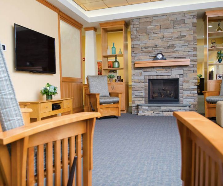 A cozy living room with a stone fireplace and modern wooden furniture.