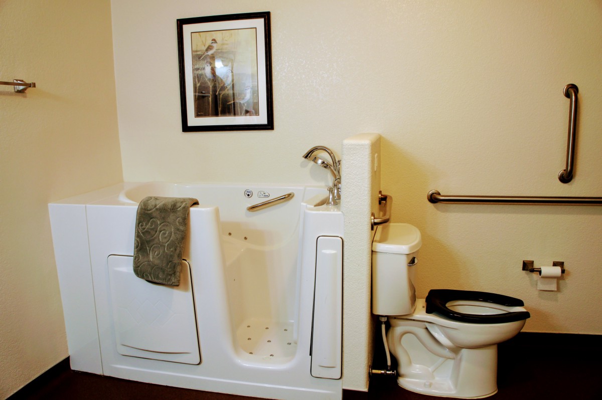 An accessible bathroom with a walk-in tub and grab bar.