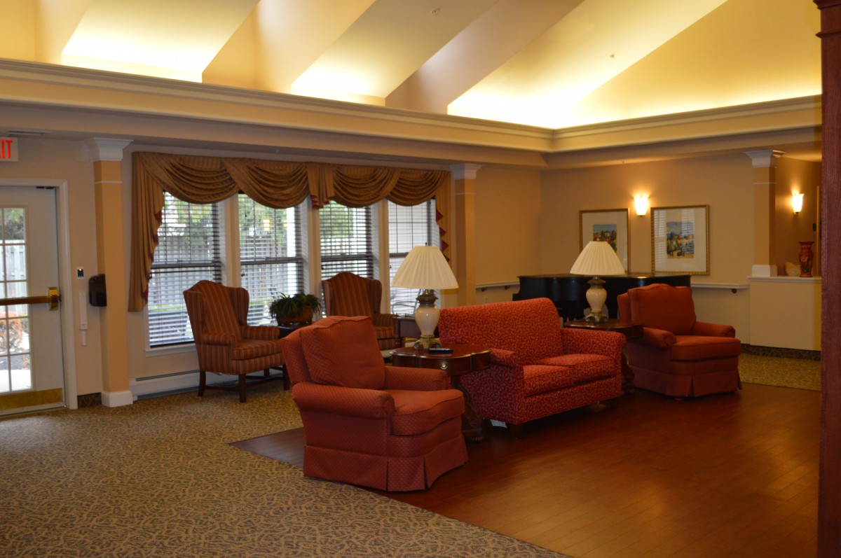 A cozy living room with comfortable seating, warm lighting, and elegant drapes.