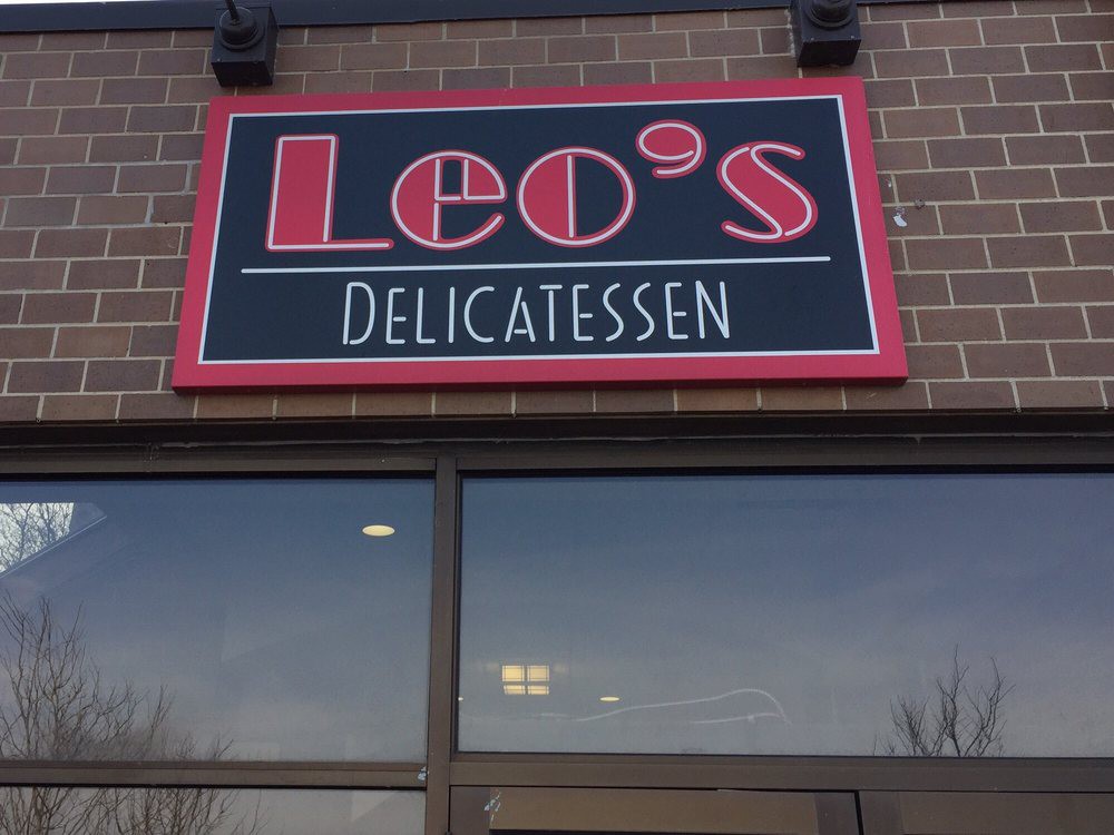 Leo's Delicatessen storefront with signage on a brick building.