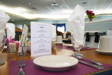 A neatly arranged dining table with a menu and napkin in a restaurant setting.