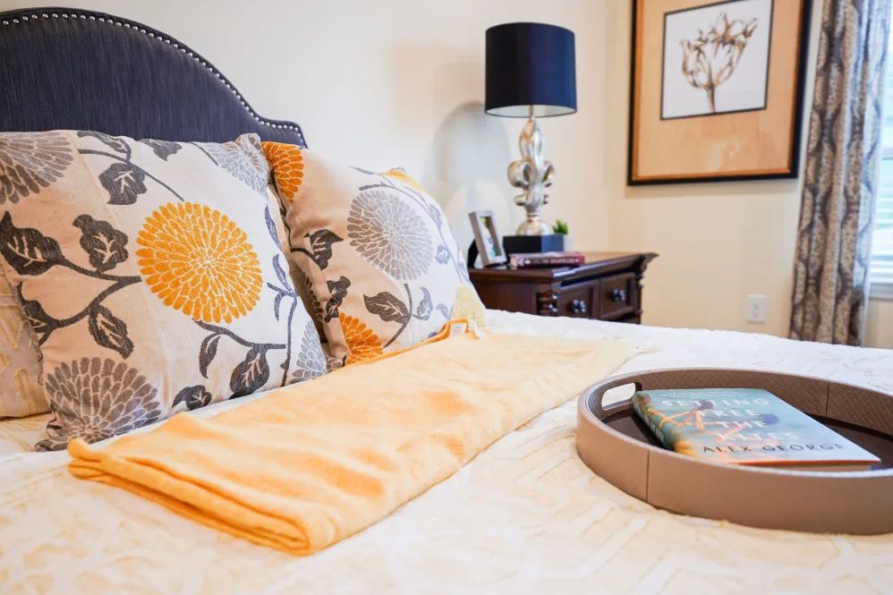 A cozy bedroom setup with decorative pillows and a stylish bedside table.