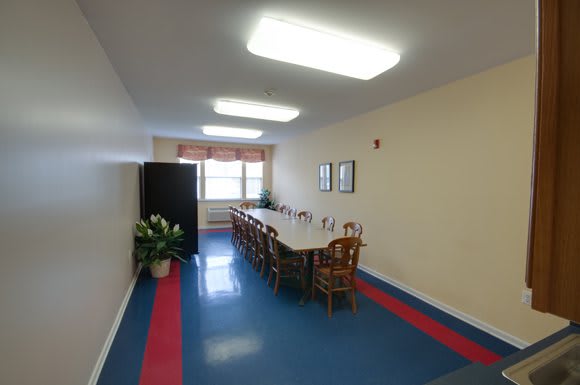 A long conference room with a central table and chairs, suitable for meetings.
