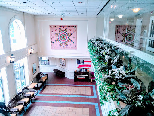 A spacious lobby featuring vibrant artwork, floral decorations, and a cozy seating arrangement.