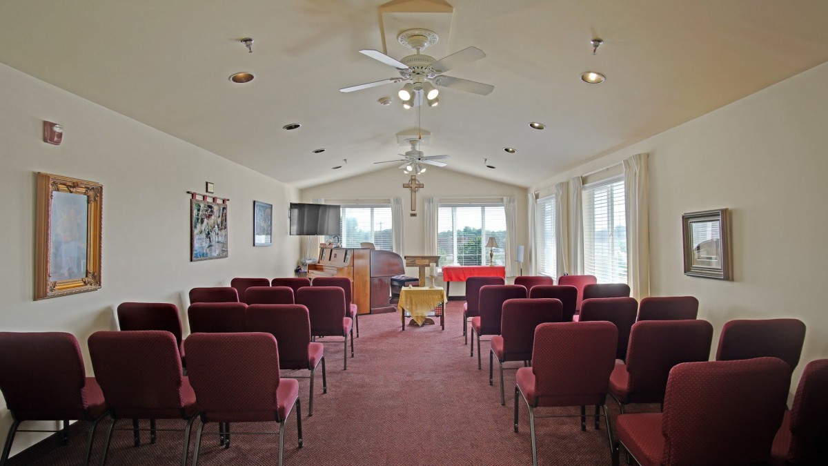 An interior view of a church auditorium with rows of seating and a pulpit at the front.