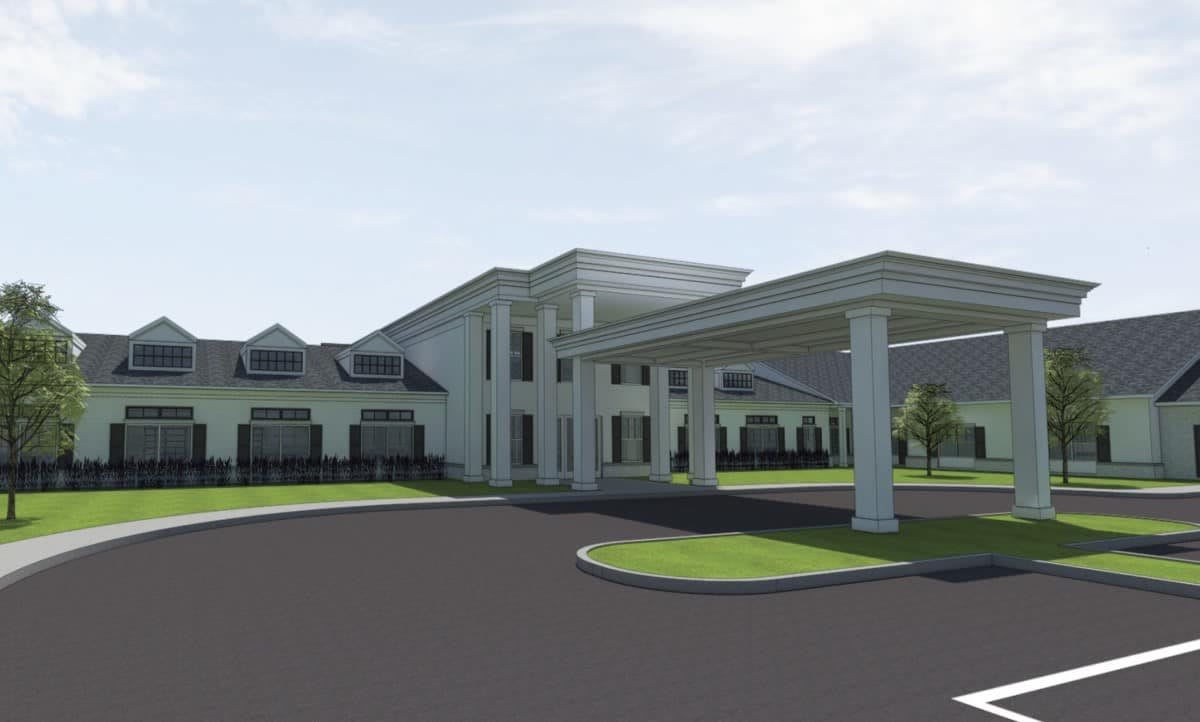 A modern building with a covered entrance and landscaped surroundings.