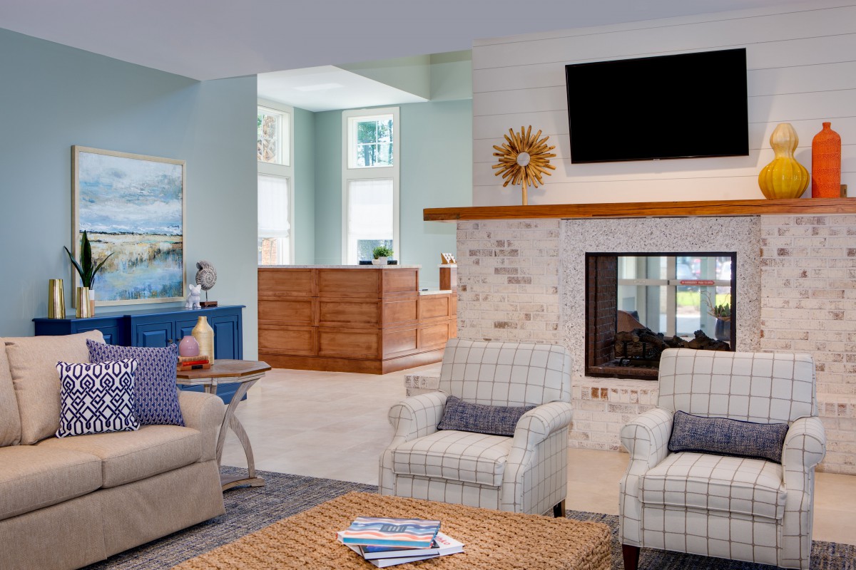 A modern living room with comfortable seating, a fireplace, and a TV mounted above it.