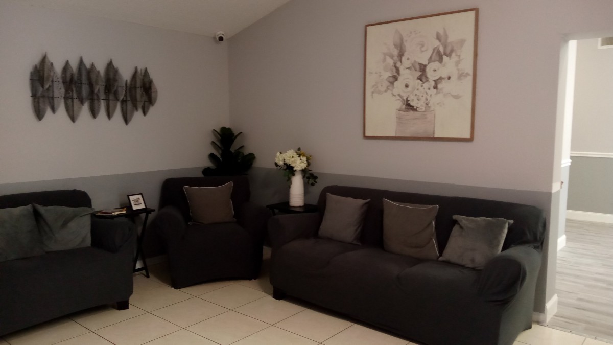 A modern living room with dark sofas and decorative artwork.
