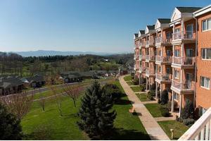 Scenic view of apartment buildings with a pathway and lush green surroundings.