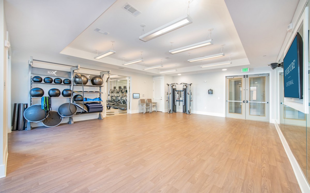 A spacious gym area equipped with yoga balls, weights, and other fitness equipment.