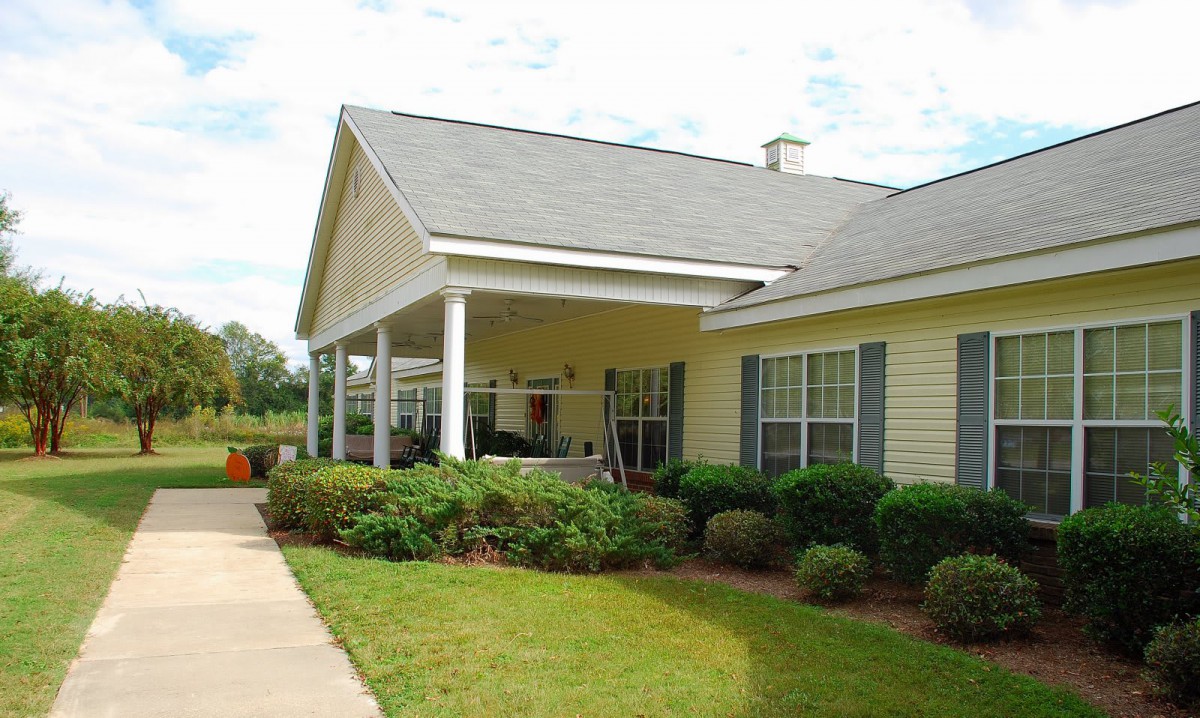 A suburban house with a porch and well-maintained lawn.
