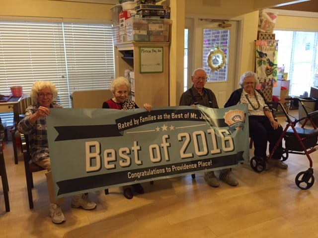 A group of people holding a 'Best of 2018' banner, celebrating an achievement.