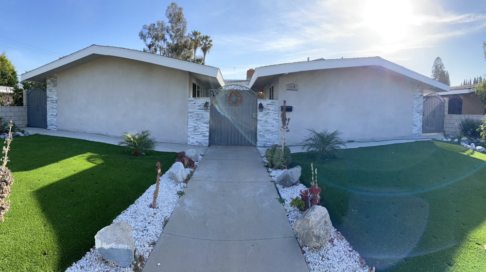 A pathway leading to a modern house with a landscaped garden.