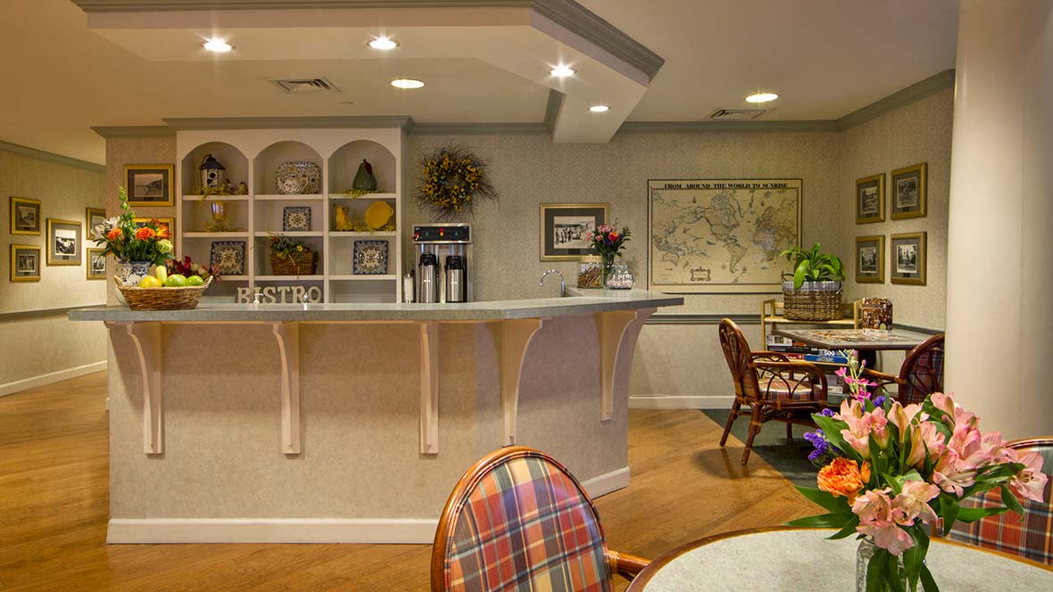 A cozy reception area with a counter, bookshelves, and warm lighting.