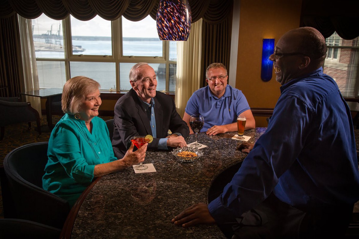 A group of four people having a conversation around a table indoors.
