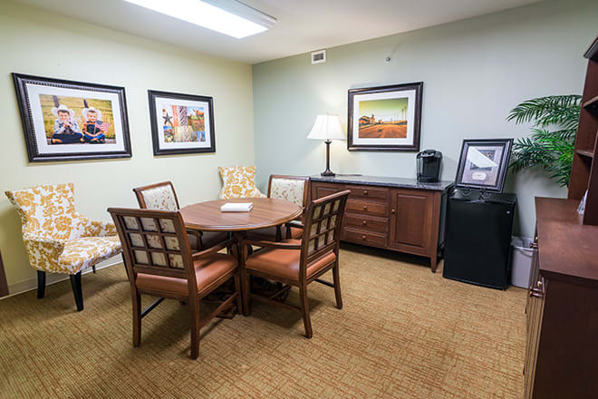 A small meeting room with a round table, chairs, and decorative artwork on the walls.