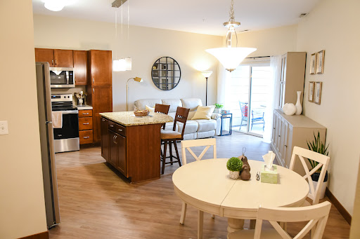 A modern open-concept kitchen and living area featuring wooden cabinetry and a cozy dining space.