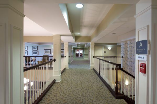 A well-lit hallway with carpeted floors and decorative railings.
