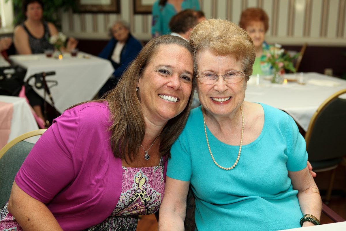 Two women smiling at a gathering.
